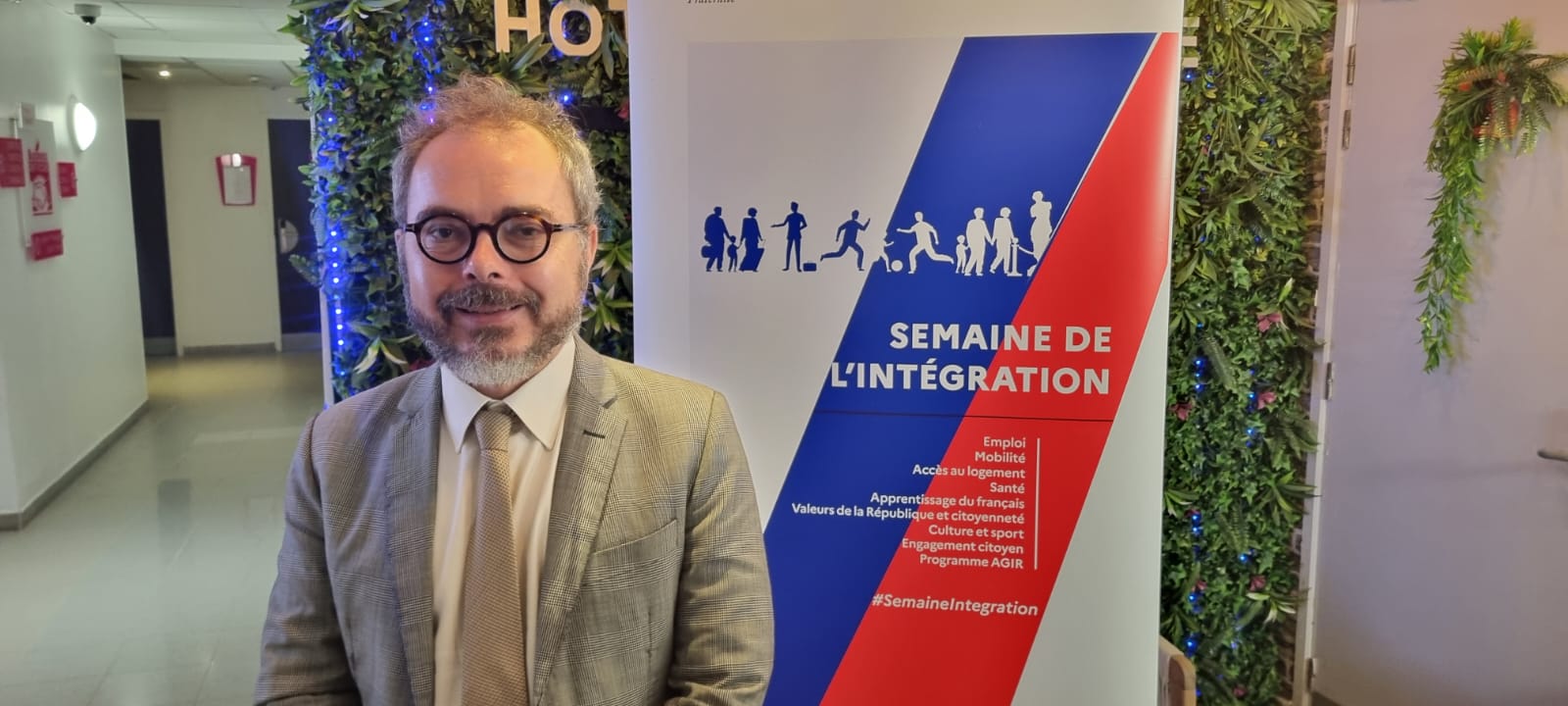Le préfet devant le visuel de la Semaine de l’intégration en Martinique.